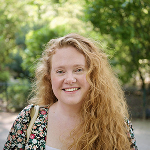 Lucy Obbard, a woman with long wavy ginger hair, smiling at the camera.